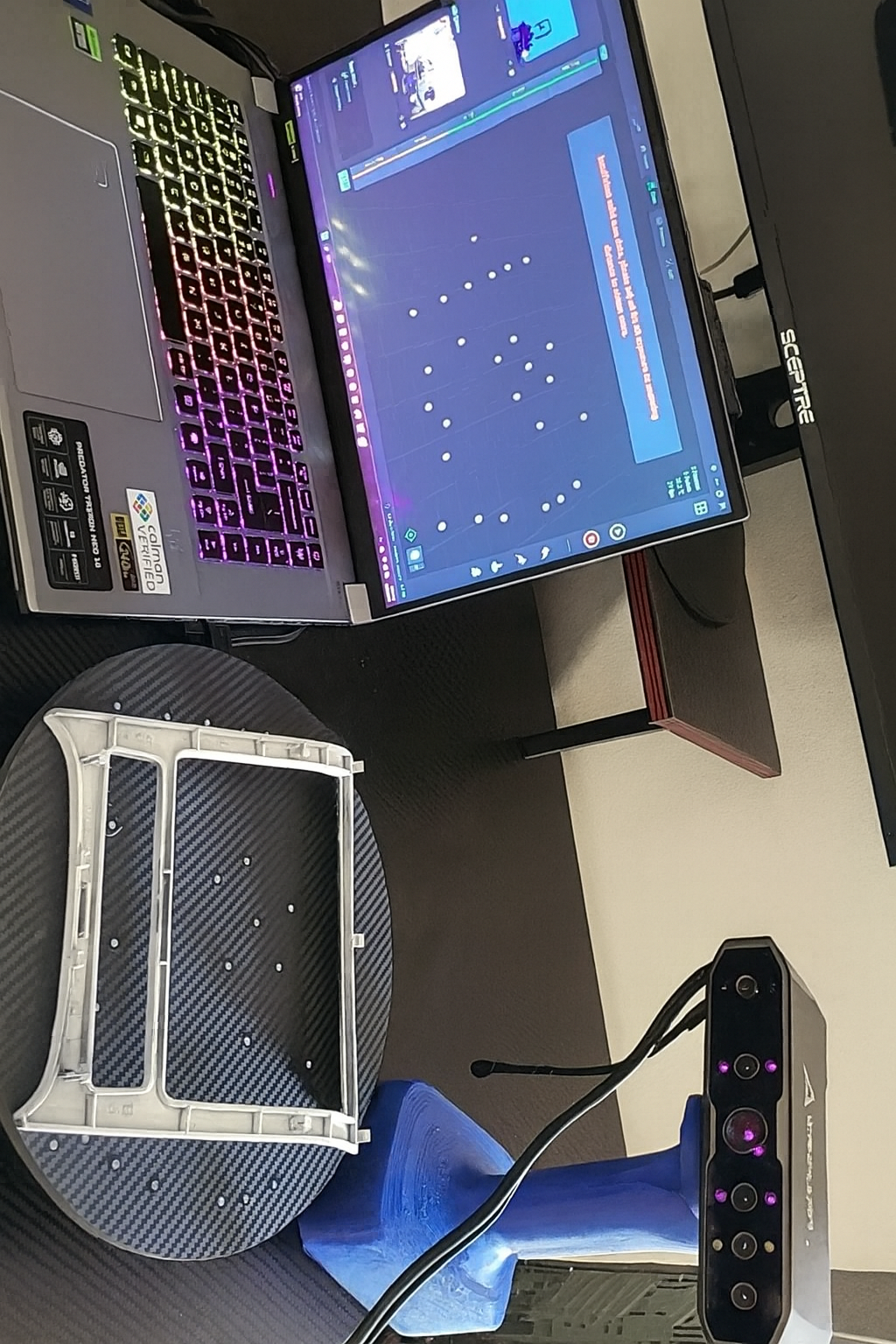 3D scanner setup with a laptop on a desk, next to a monitor. Alikitty's 3D scanning